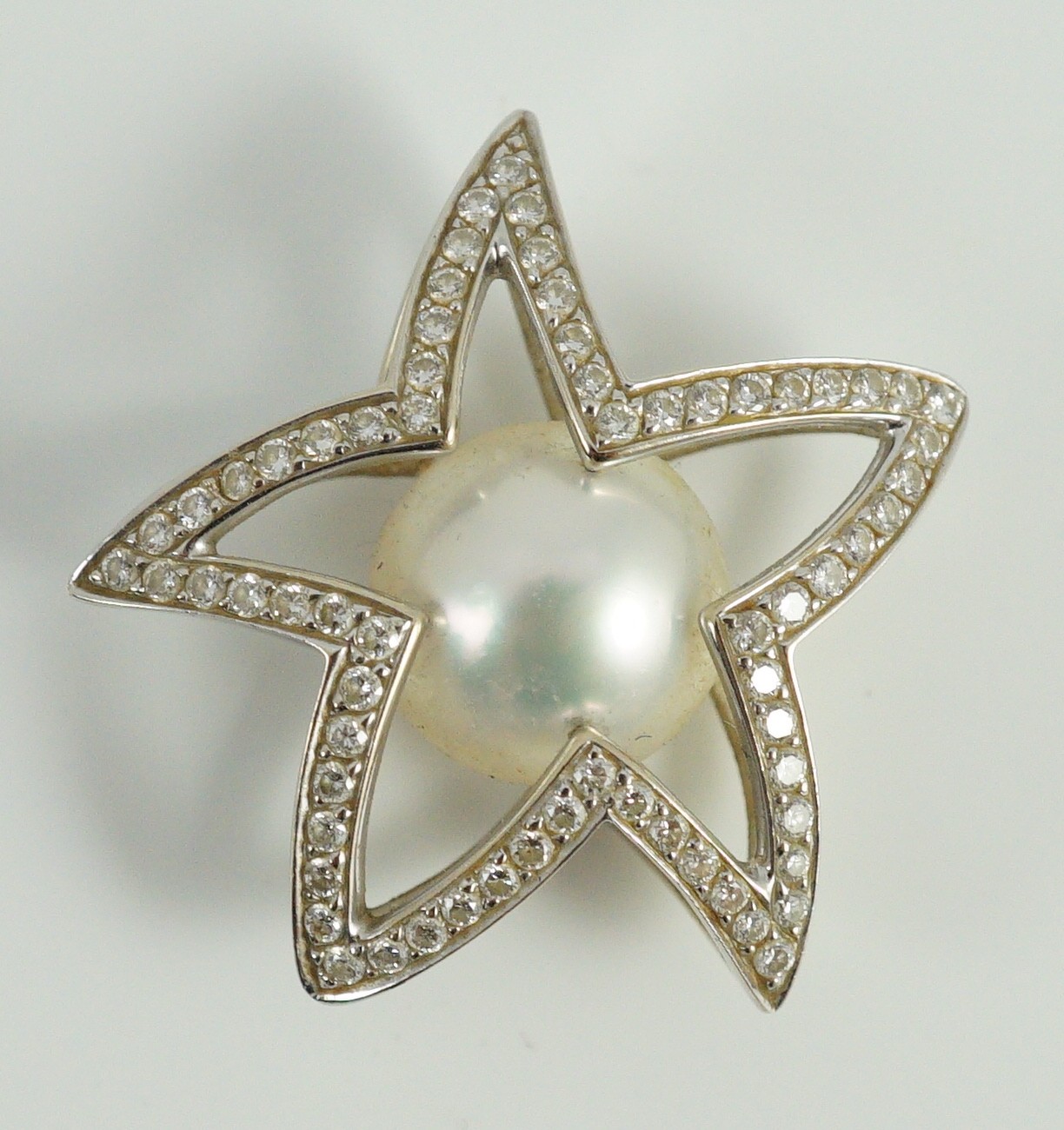 A modern Australian Kailis 18k white gold, single stone South Sea pearl and diamond chip cluster set 'Icon Star' pendant